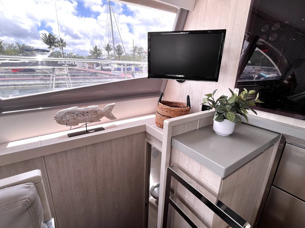 Bright catamaran galley with a TV and a sea view