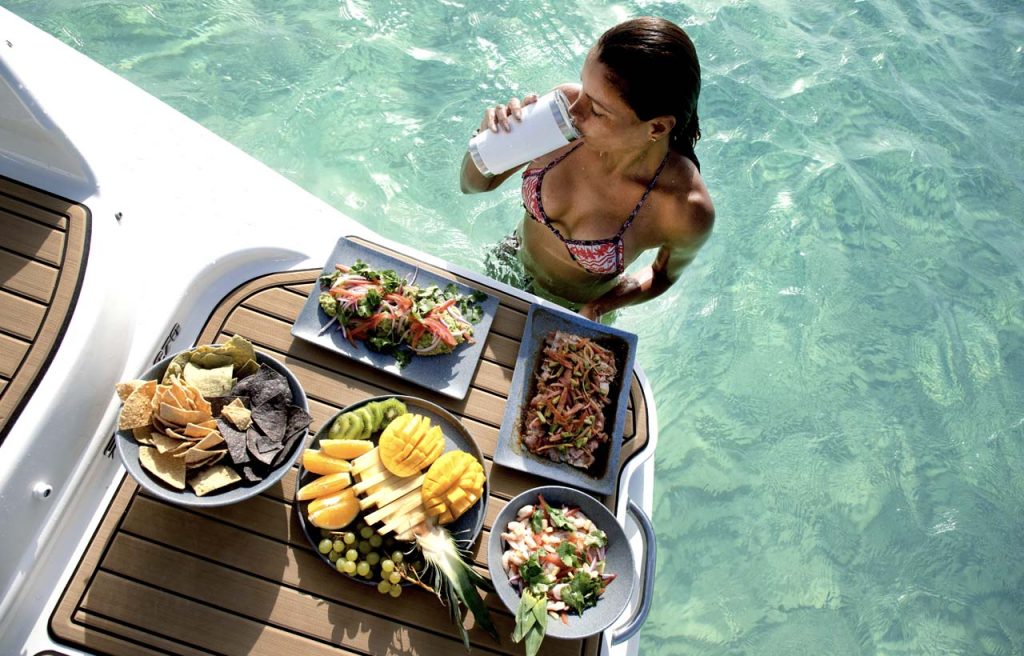 Guest enjoying a drink beside platters of fresh fruit and seafood