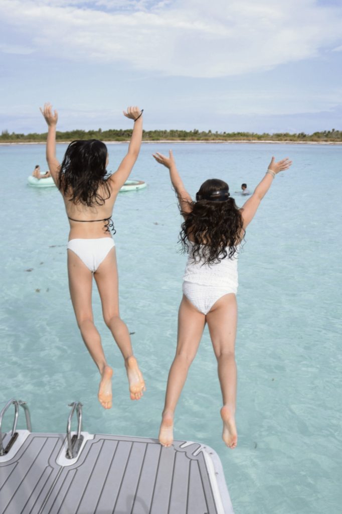 Kids jumping for joy in the shallow water