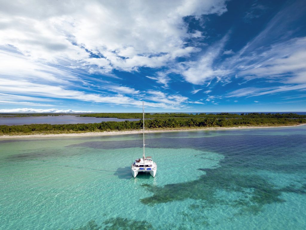 Catamaran at anchor under a bright blue sky