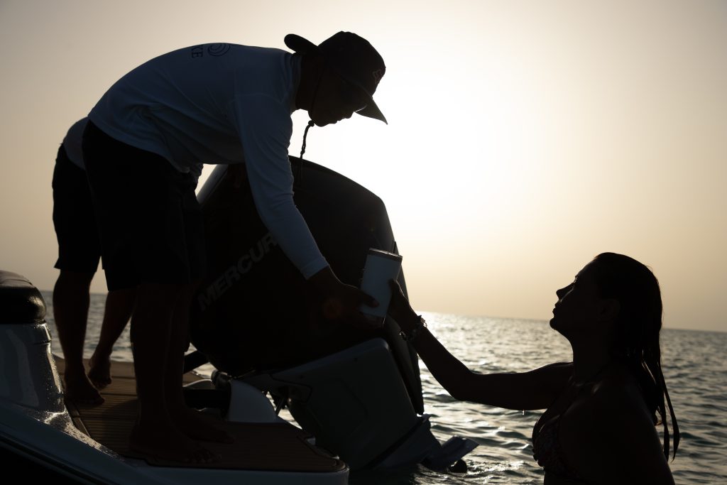 Our captain helping a guest back on board at sunset