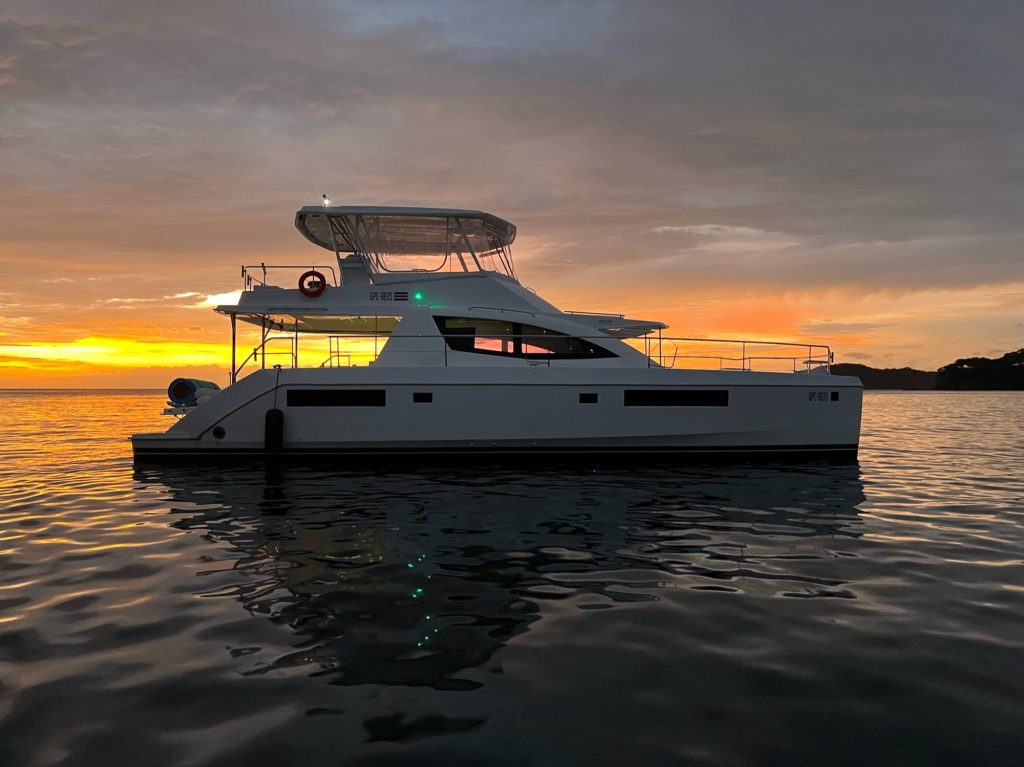 Luxury catamaran at dusk with an orange sky