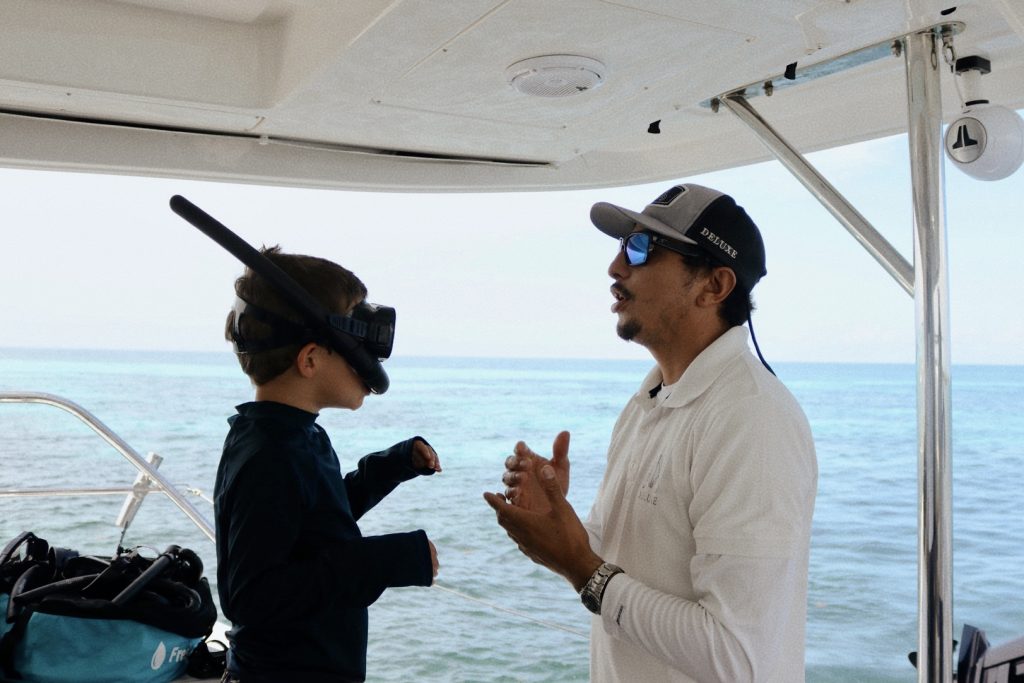 Crew member briefing a guest before snorkeling