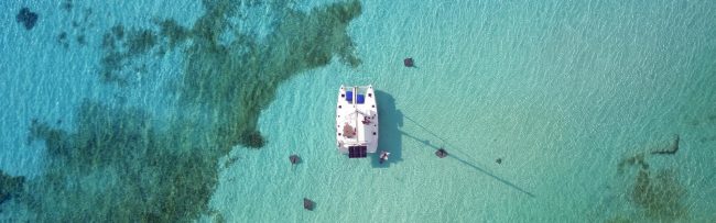 Private catamaran anchored over the reef in turquoise water, Cozumel