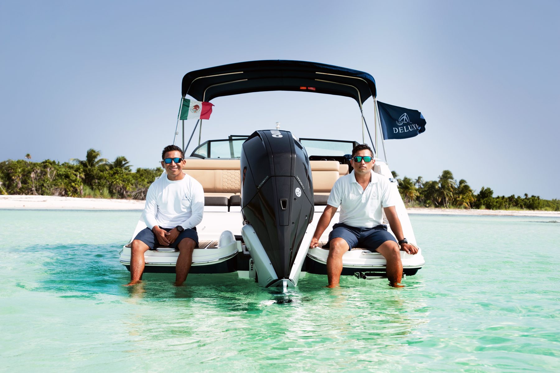 Crew relaxing on the swim platform of the Sea Ray 27 at a Cozumel sandbar